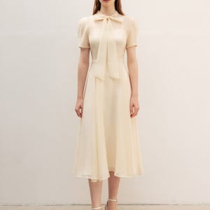 [비에이유 바이 브라이드앤유] 릴 시스루 퍼프숄더 리본 타이 원피스 오트밀