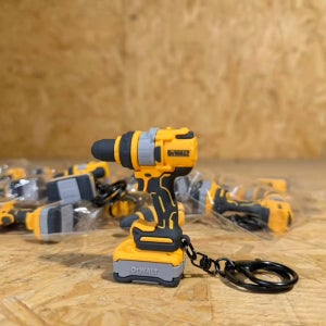 DEWALT DCD1007 전기 드릴 모델 열쇠고리 펜던트는 고무 소재로 제작되었으며 검정색 걸이 링이 있습니다.